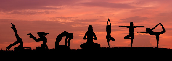 Silhouette de femmes en posture de yoga au coucher du soleil